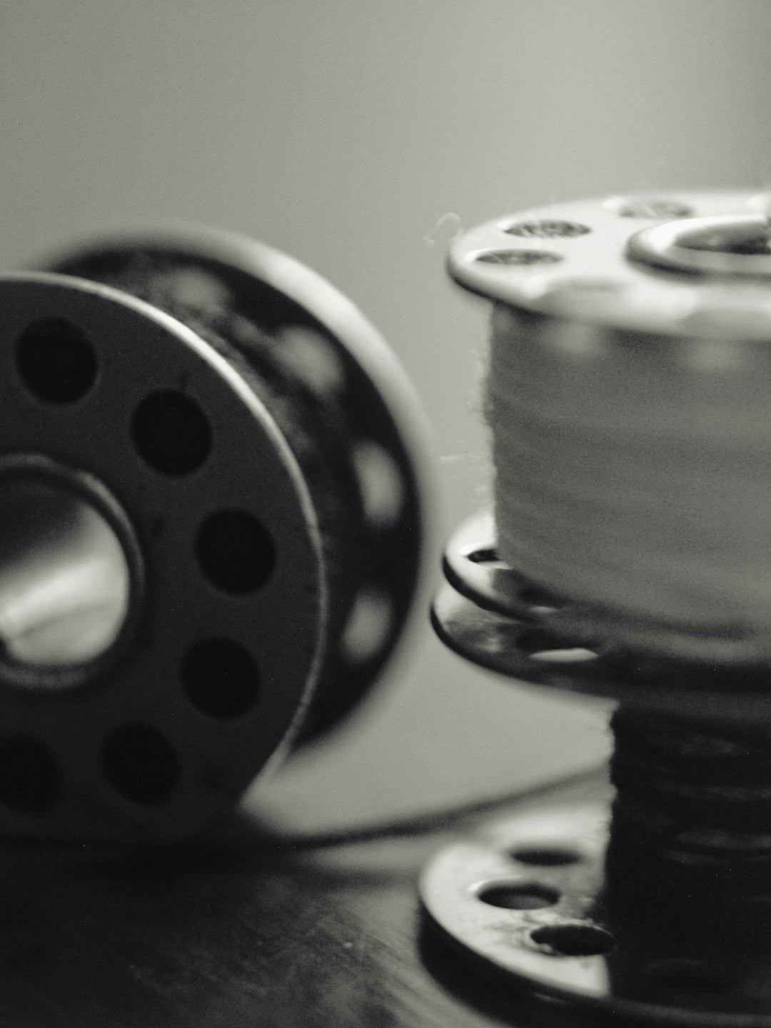 gallery-2 two-sewing-bobbins-one-with-thread-in-black-and-white-ise2njjafjc